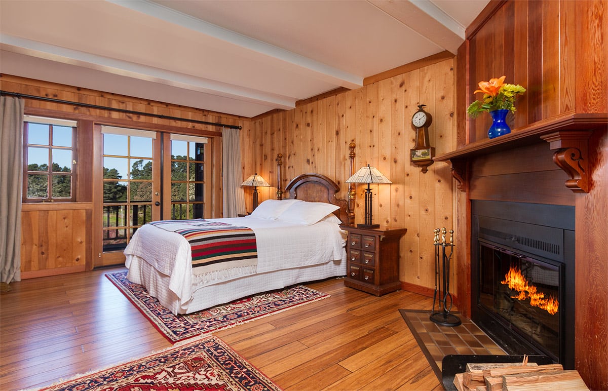 mendocino coast bed and breakfast with ocean views, fireplace, red couch and queen bed