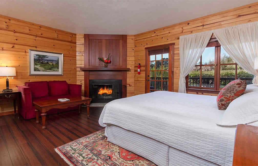 mendocino coast bed and breakfast with ocean views, fireplace, red couch and king bed