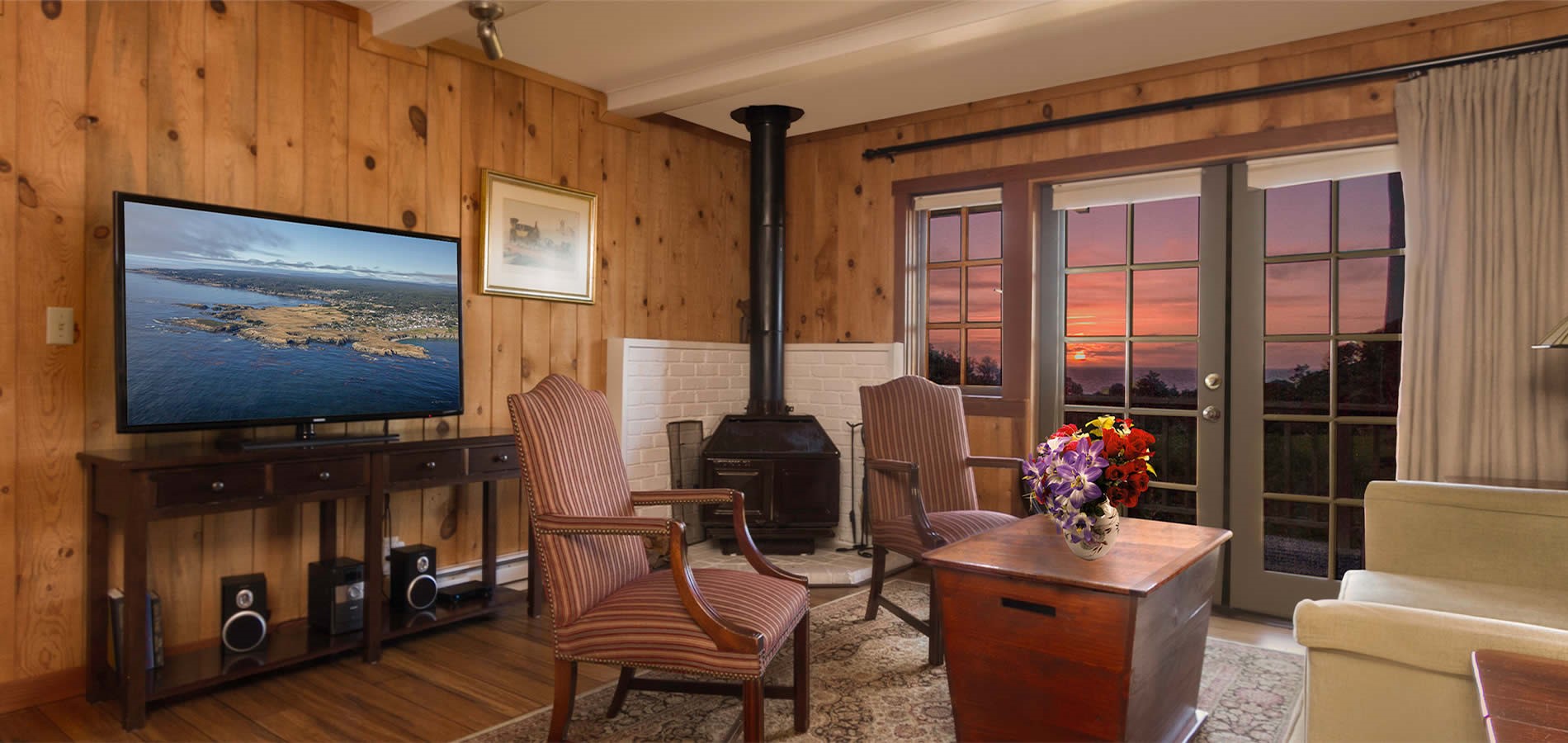 mendocino hotel stanford inn guest room with tv, chairs and sunset over the ocean